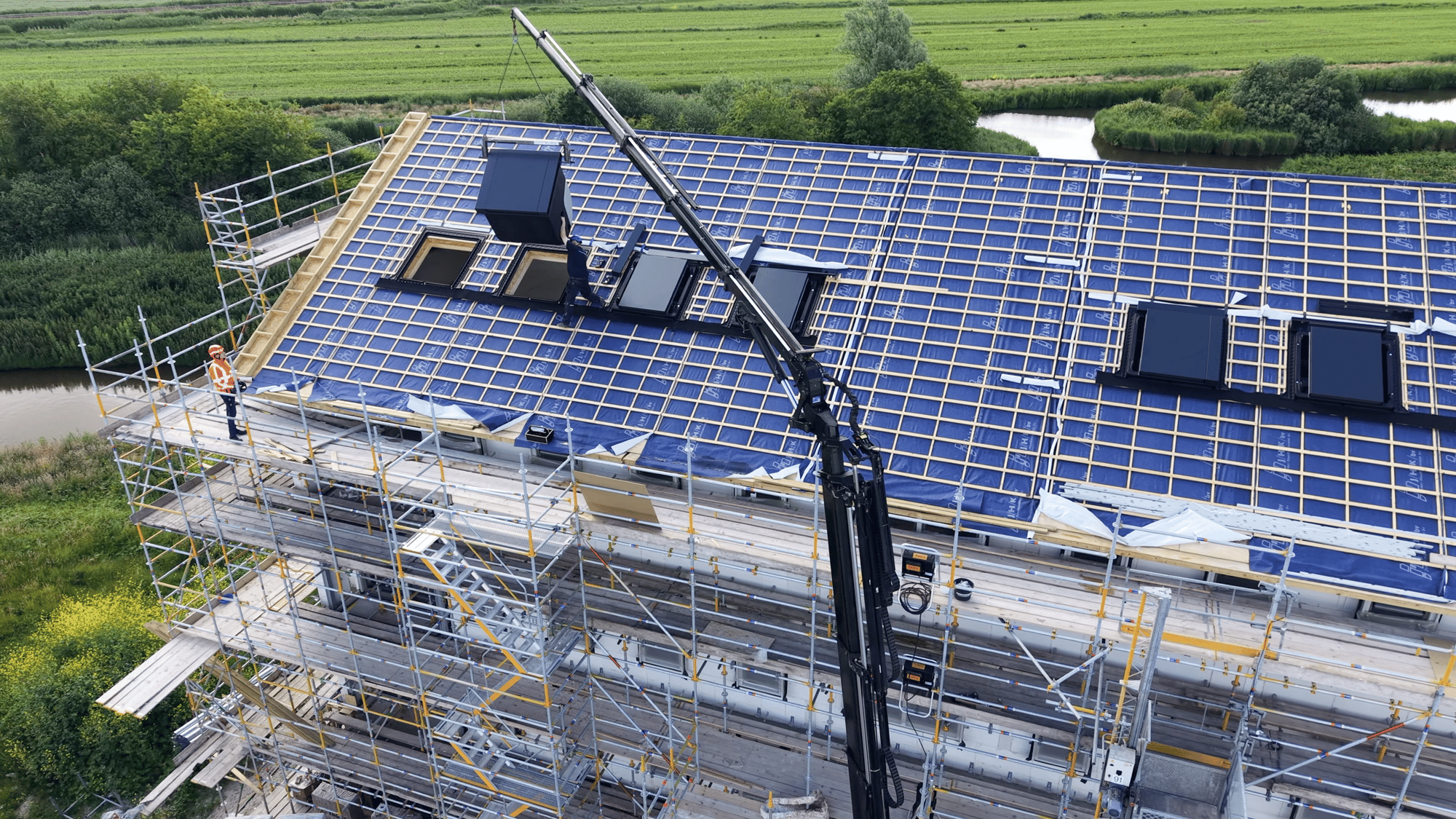 Autolaadkraan hijst een prefab HydroTop naar het schuine dak van een appartementengebouw in Waterrijk, Oosthuizen