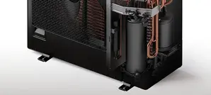 Opengewerkte buitenunit van een split-warmtepomp met de compressor en de koperen leidingen van het koudemiddelcircuit