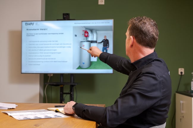 DHPS-collega geeft een presentatie in de vergaderruimte DHPS-collega geeft een presentatie in de vergaderruimte