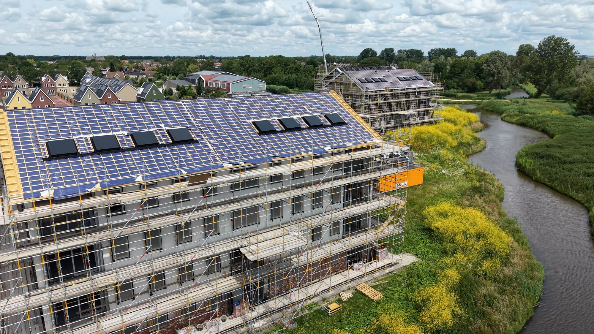 Schuin dak van een appartementengebouw in Waterrijk Oosthuizen met lage HydroTop-dakkappen in RAL 7021 (zwartgrijs)