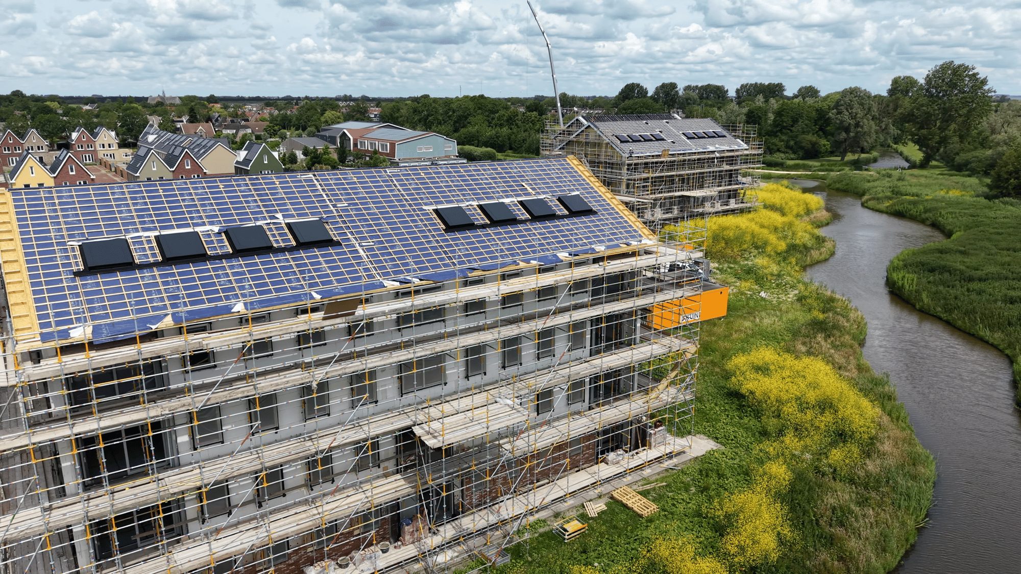 Schuin dak van een appartementengebouw in Waterrijk Oosthuizen met lage HydroTop-dakkappen in RAL 7021 (zwartgrijs)